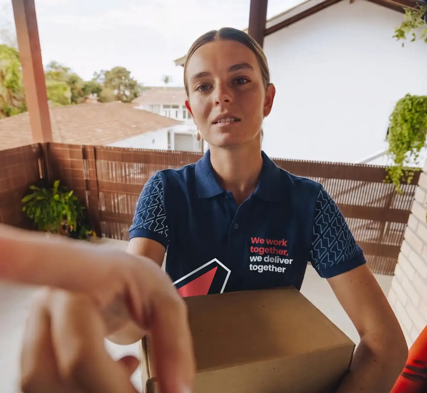 Repartidora de Service Club entregando un paquete en la puerta de una casa