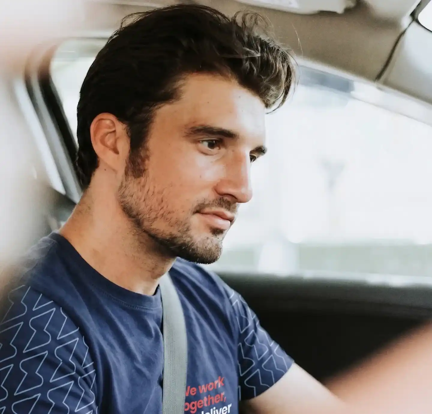 Conductor con la camiseta de Service Club al volante, con el cinturón puesto